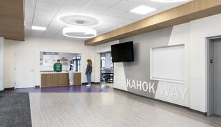 A modern interior features a welcoming service area, large display screen, and inspirational decor, creating an inviting atmosphere.