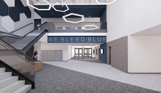 A modern interior features a staircase, large windows, hexagonal designs, and a wall proclaiming "WE BLEED BLUE," creating a vibrant atmosphere.