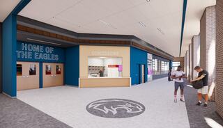 A modern school hallway features a vibrant blue and beige design, with "Home of the Eagles" signage and students engaged nearby.