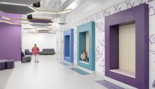 A colorful, modern space features playful wall art, cozy nooks, and seating areas, creating an inviting atmosphere for children and families.