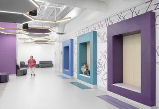 A modern, colorful learning space features cozy nooks, playful decor, and comfortable seating, inviting exploration and creativity.