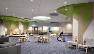 A bright, inviting playroom features green accents, cozy seating, and various play areas, designed for children's exploration and creativity.