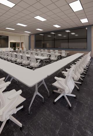 A large, modern conference room features multiple white tables arranged in a U-shape, surrounded by sleek, ergonomic chairs.
