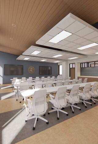 A modern conference room features white ergonomic chairs and large screens, with wooden accents and ample natural light.