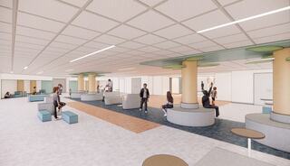 A spacious, modern interior featuring diverse seating options and pillars, with people engaged in various activities throughout the area.