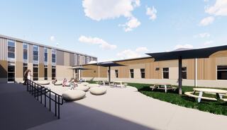 A modern outdoor space features casual seating, picnic tables, and shaded areas, surrounded by a contemporary building under a clear sky.