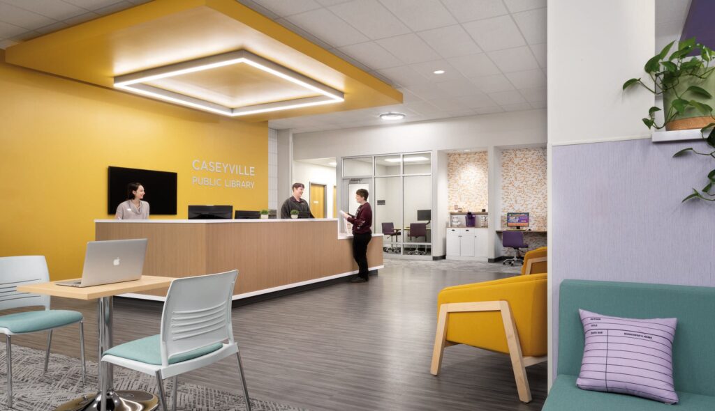 A modern reception area features a sleek front desk, vibrant yellow walls, seating areas, and workstations, promoting a welcoming atmosphere.