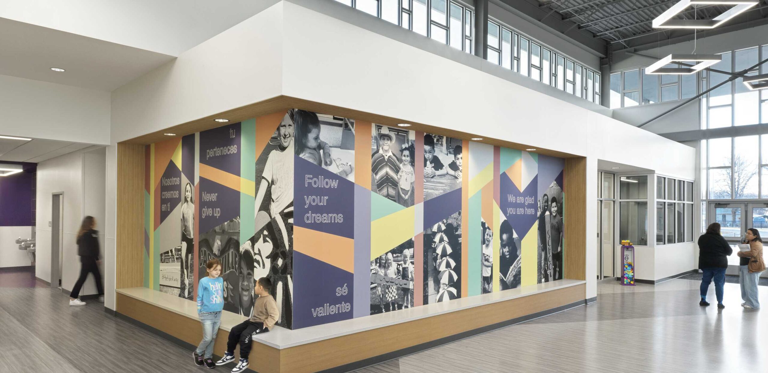 A vibrant entrance with colorful murals promoting dreams and achievements, featuring images of people and inspirational messages.