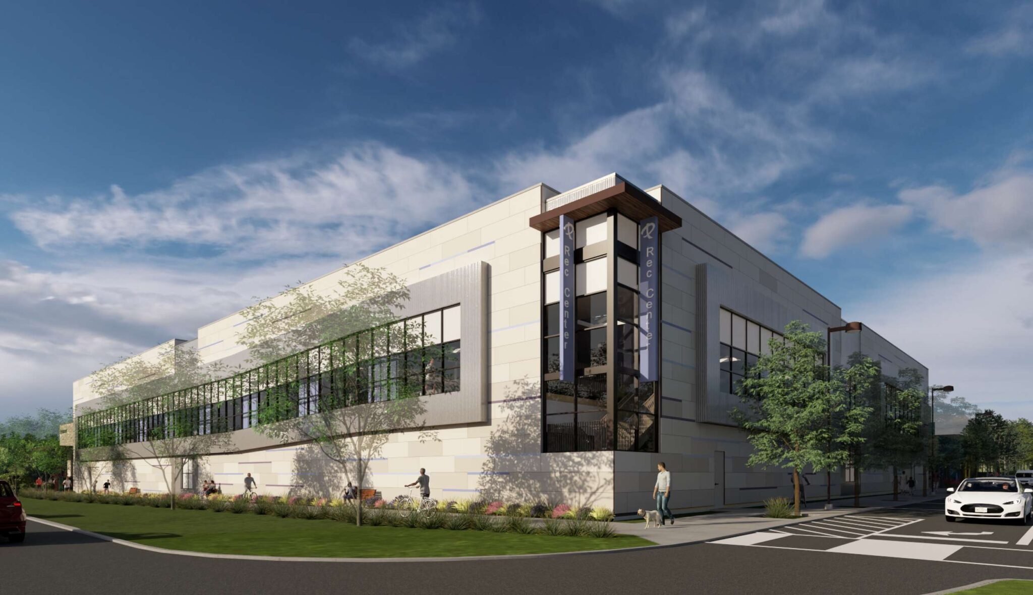 A rec center features large windows and greenery around its perimeter, set against a blue sky with scattered clouds.