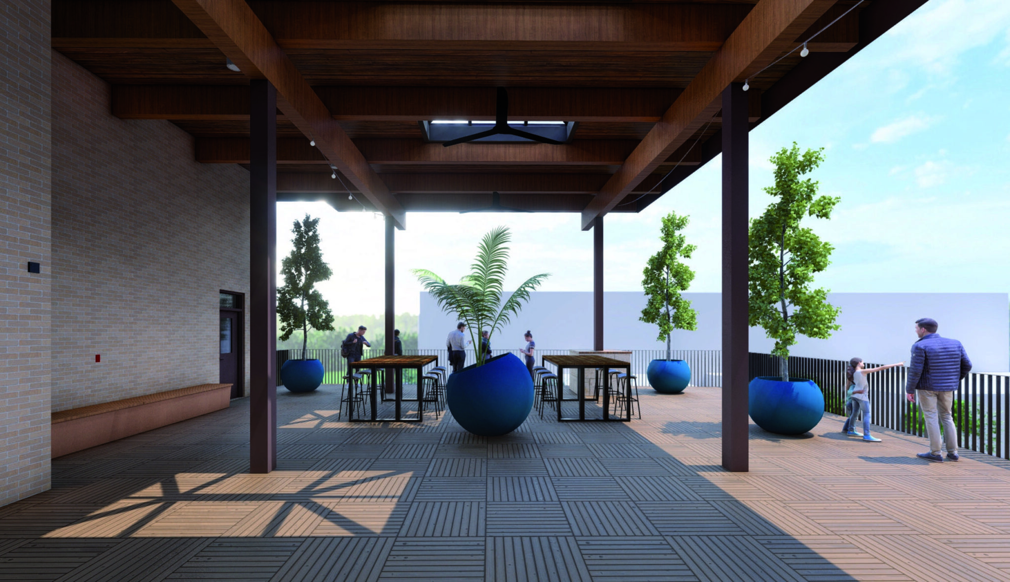 A spacious outdoor patio features large blue planters, wooden tables, and serene greenery, creating a welcoming atmosphere for socializing.