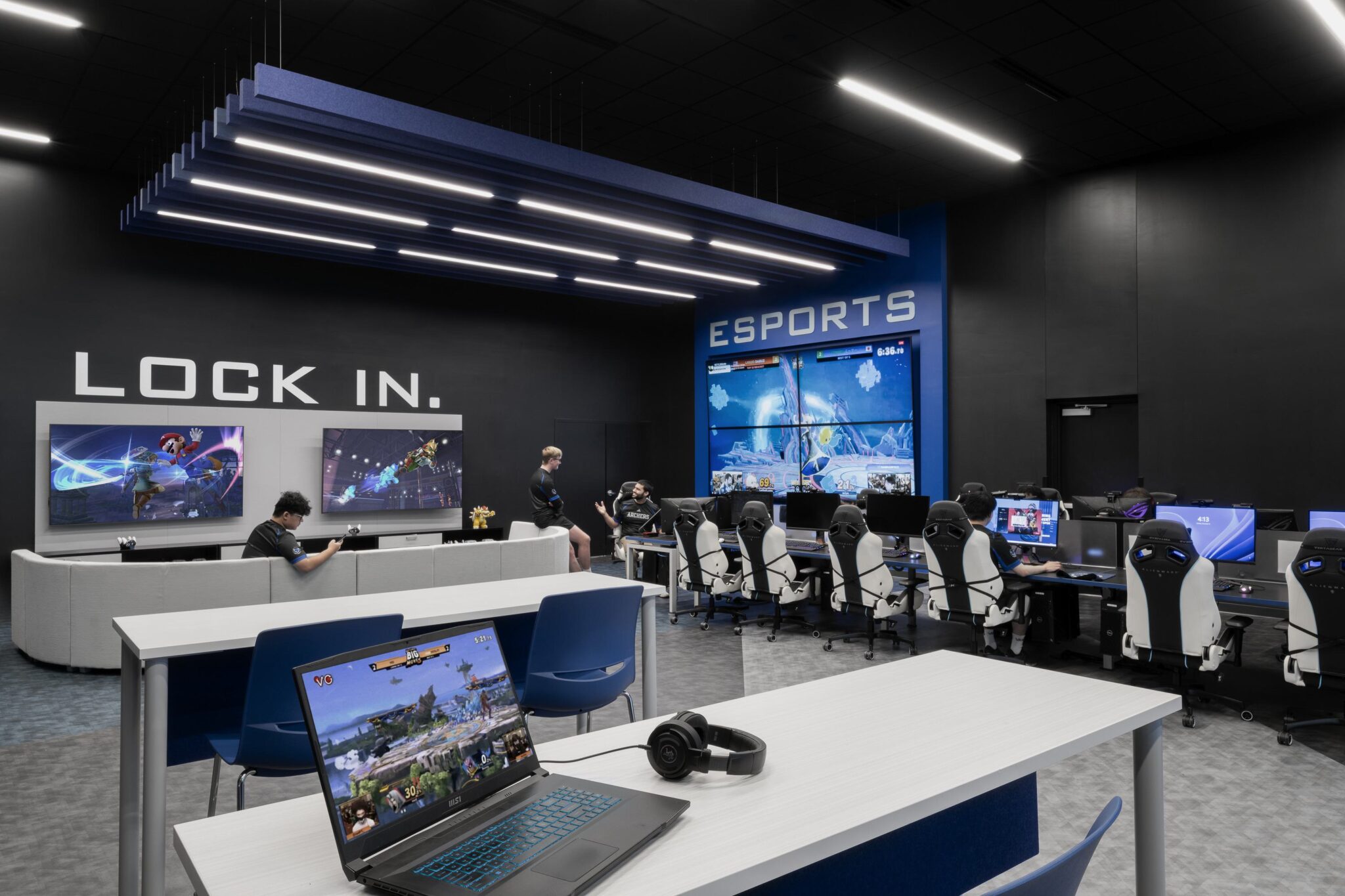 A modern esports gaming center featuring sleek workstations, large screens, and players engaged in intense gameplay, embodying a competitive atmosphere.