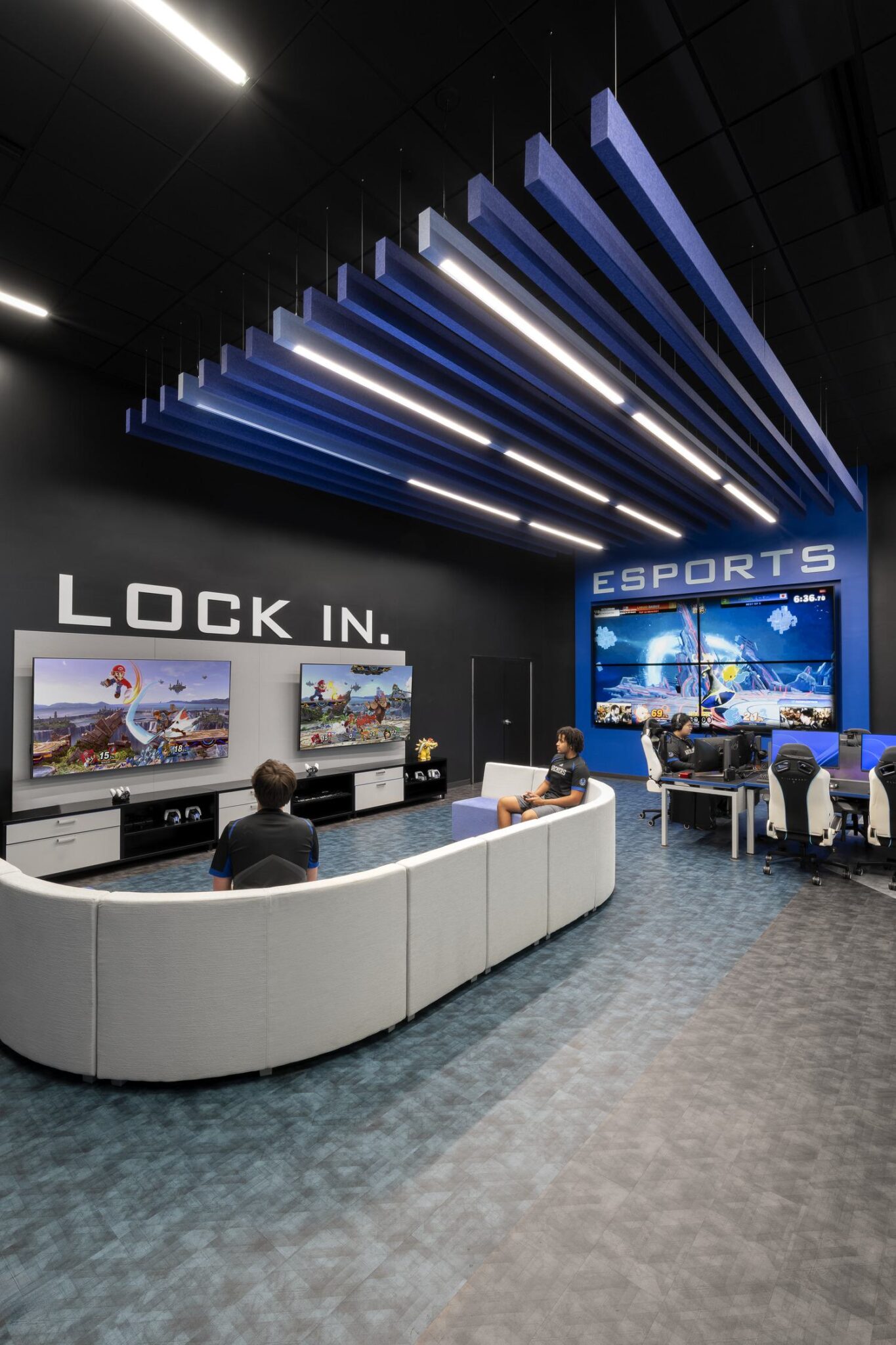 A modern esports lounge features gaming stations, large screens, and sleek seating, designed for competitive gaming and team interaction.
