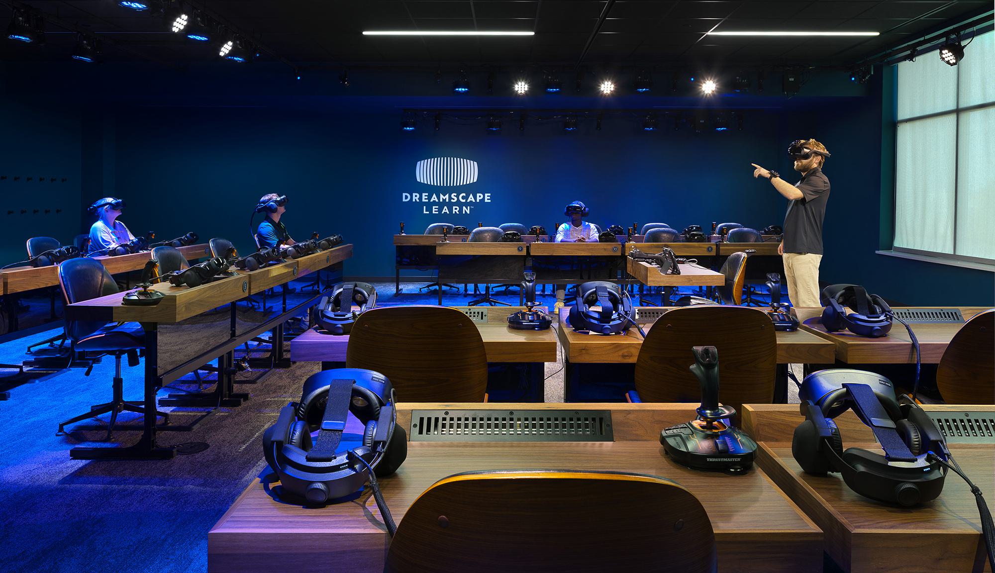 A modern classroom designed for virtual learning, featuring several students wearing VR headsets and an instructor guiding the session.
