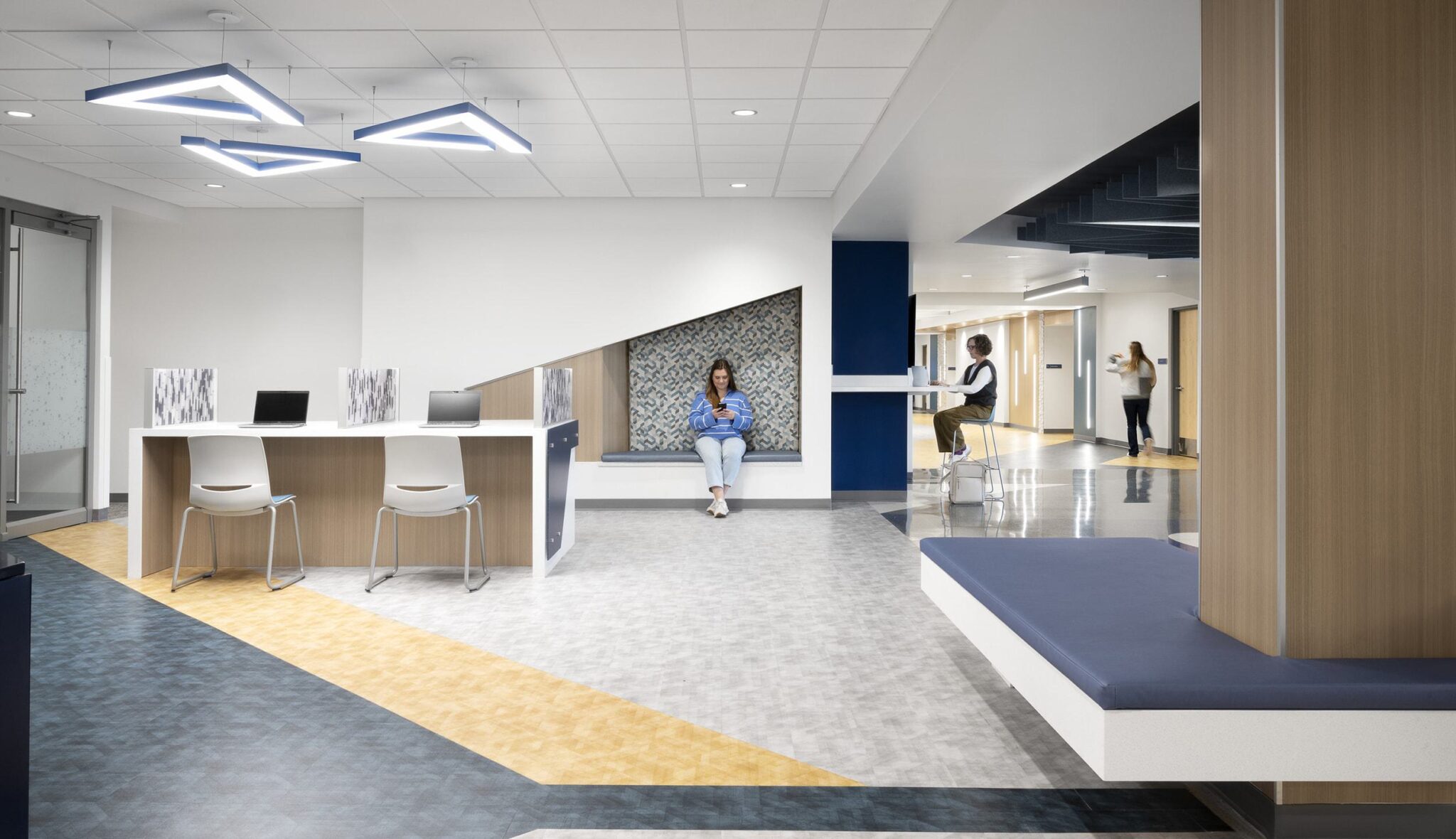 A modern, well-lit interior features a reception area with a minimalist design, seating, and decorative elements, promoting a welcoming atmosphere.