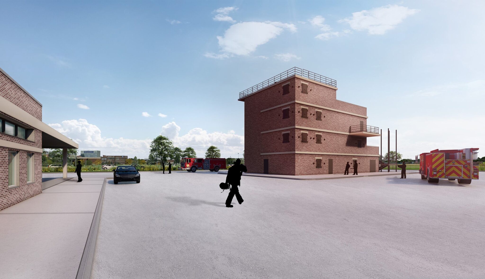 A large, modern training facility features a multi-story building, parked fire trucks, and personnel in a spacious outdoor area under a clear sky.