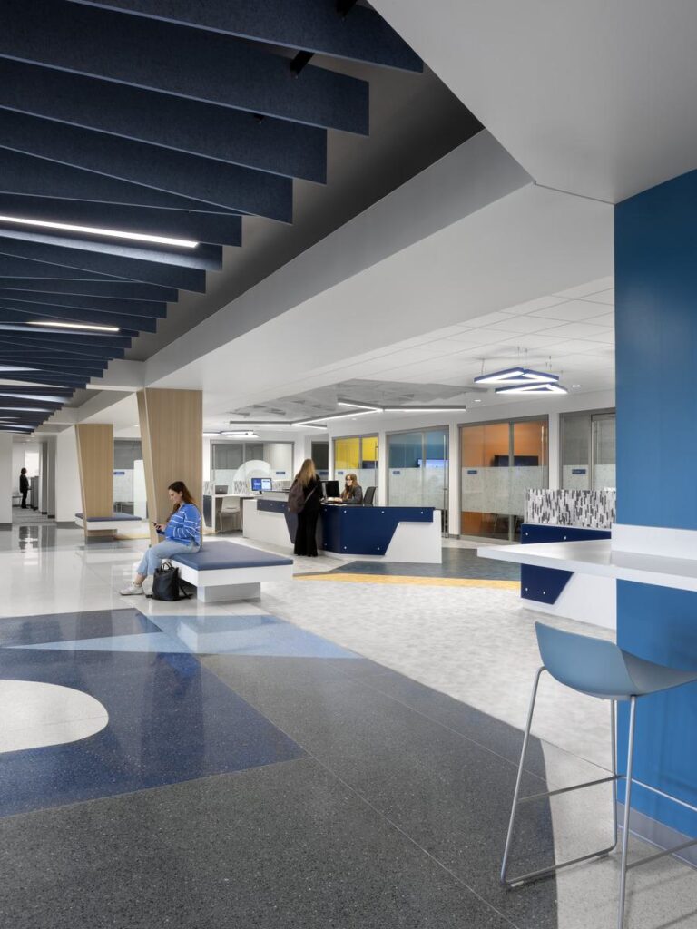 A modern reception area features sleek designs, vibrant colors, and comfortable seating, creating an inviting atmosphere for visitors.