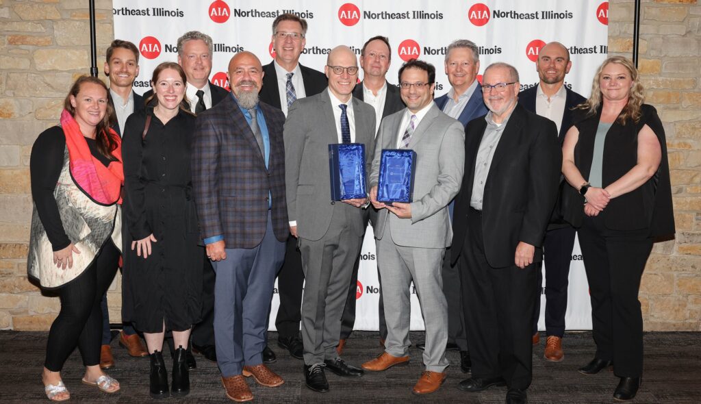 Group Photo with 13 team members from FGM Architects at the 2025 AIA NEI Awards ceremony with two awards