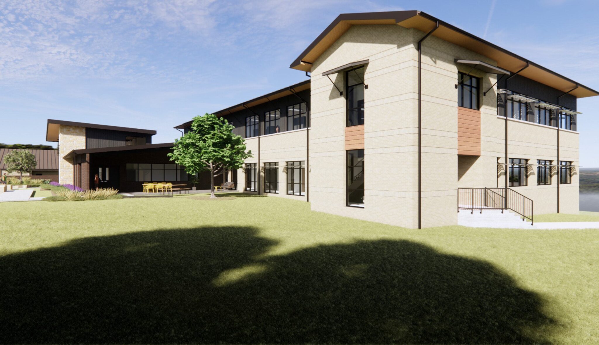 A modern two-story building features sleek architecture, large windows, and a surrounding lawn with a tree, offering a welcoming atmosphere.