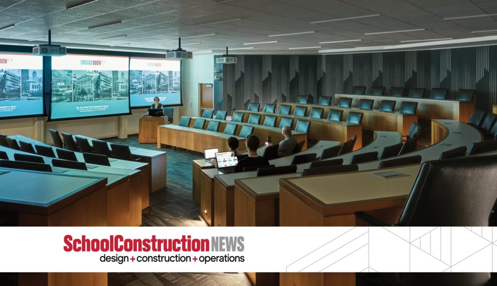 A modern lecture hall with tiered seating, large screens, and a sleek design, designed for presentations and collaborative learning.