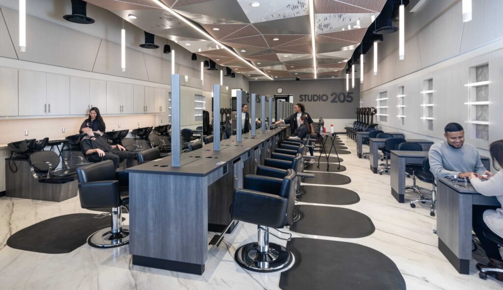 A modern salon features sleek stylist stations, comfortable chairs, and ample lighting, creating a welcoming atmosphere for customers.