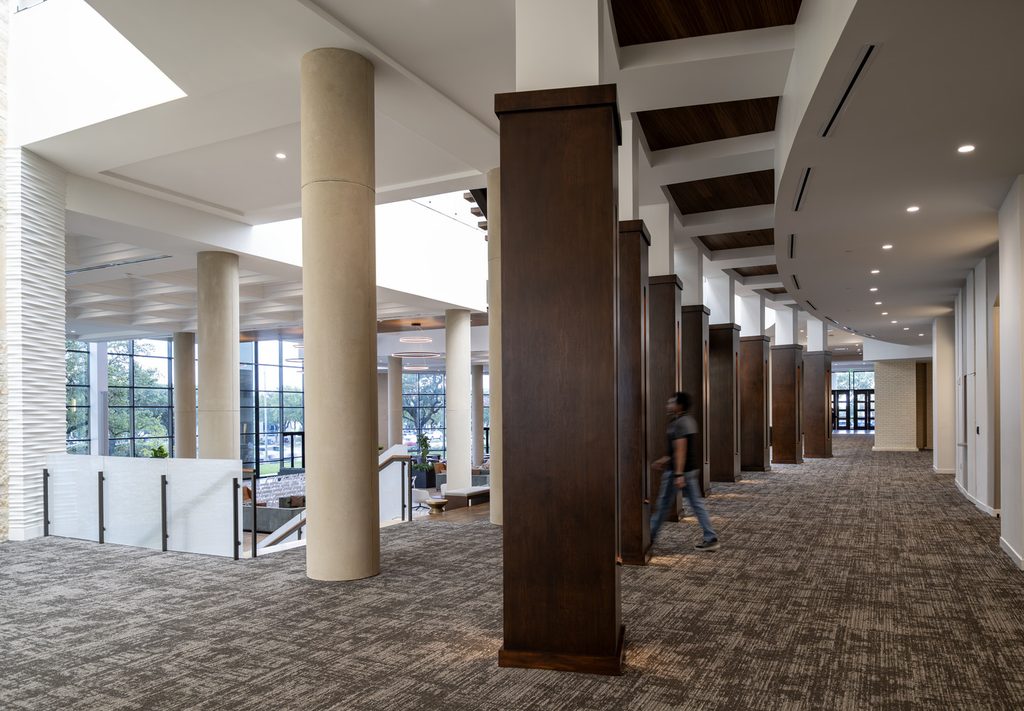 Hallway and landing in Cornerstone Church leading down to the banquet hall space, with rich brown tones, creams, tans and soft whites