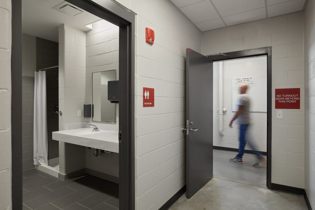 Decontamination shower and restroom and signage that shows the separation of turnout gear before entering the main part of a fire station.